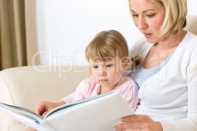 Mother with little girl read book together