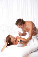 Young couple discussing in white bed