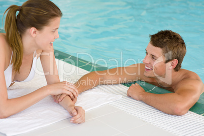 Swimming pool - young loving couple hold hands