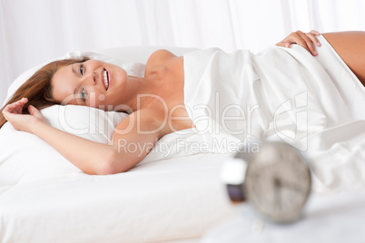 White lounge - Smiling woman lying in white bed