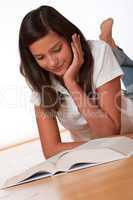 Teenager reading book lying down