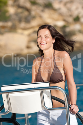 Beautiful young woman standing on luxury boat