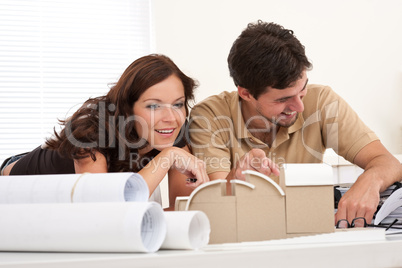 Smiling man and woman with architectural model