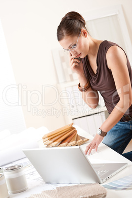Female interior designer with laptop and phone