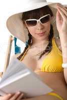 Beach - Young woman in bikini sunbath with book