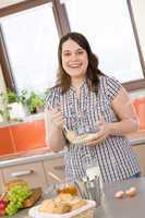 Bake - happy woman with ingredients in kitchen