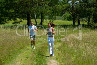 Young couple jogging outdoors in spring nature