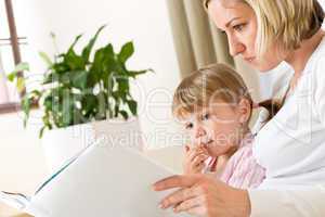 Mother with little girl read book together