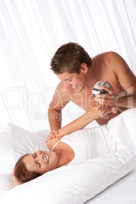 Young couple having fun in white bed