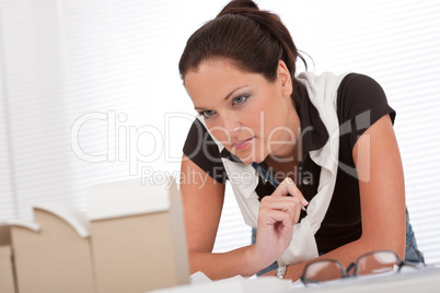 Young female architect watching architectural model