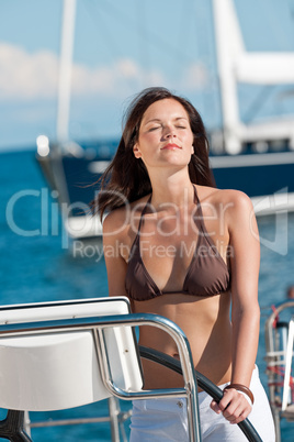 Beautiful young woman standing on luxury boat