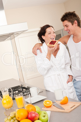 Young man and woman eating toast in the kitchen