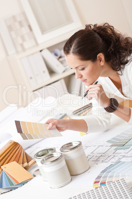 Young female interior designer at office with paint