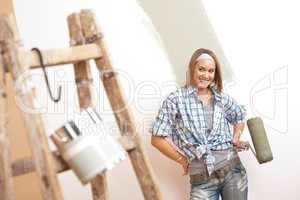 Home improvement: Young woman with paint roller and ladder