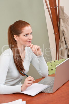 Long red hair woman working at office with laptop