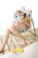 Beach - Young woman in bikini with book sunbathing