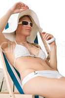 Beach - woman in bikini with hat sunbathing