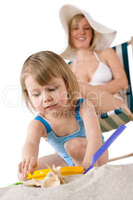 Mother with child playing with beach toys