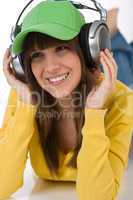 Happy female teenager enjoy music with headphones