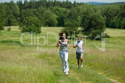 Young couple jogging outdoors in spring nature