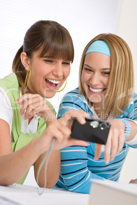 Two young cheerful woman with camera