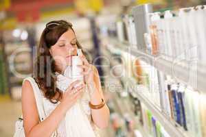 Shopping cosmetics - woman smelling shampoo