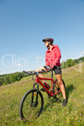 Young woman with mountain bike in spring nature