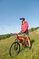 Young woman with mountain bike in spring nature