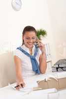 Female architect with phone sitting at office