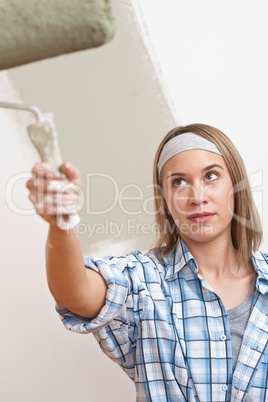 Home improvement: Young woman with paint roller