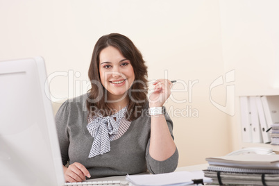 Young business woman working with computer at office
