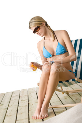 Beach - Young woman in bikini  apply suntan lotion