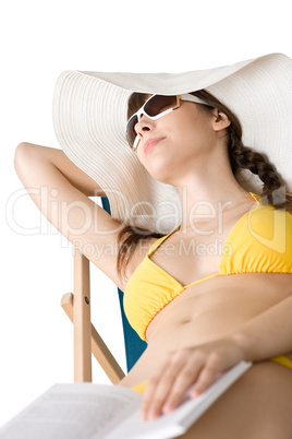 Beach - Woman in bikini lying sunbathing with book and hat