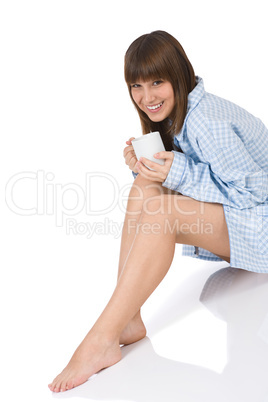 Smiling female teenager with cup of tea