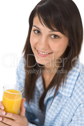 Smiling woman drink orange juice in pajamas