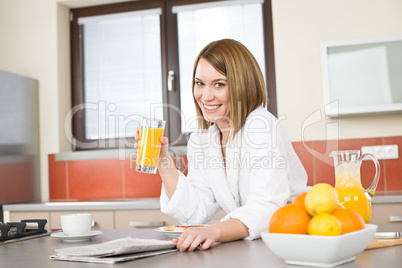 Breakfast - Smiling woman with orange juice in kitchen