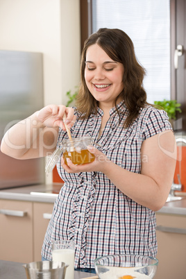 Bake - happy woman with ingredients in kitchen