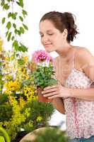 Gardening - woman holding flower pot smelling flower