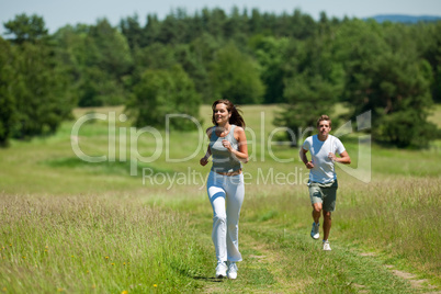 Young couple jogging outdoors in spring nature