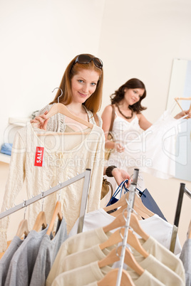 Fashion shopping - Two Happy woman choose sale clothes