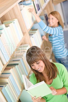 Student in library - two woman choose book