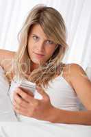 White lounge - Blond woman holding mp3 player listening to music