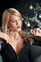 Portrait of blond sexy woman in black dress on Christmas