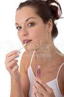 Body care series - Young beautiful woman applying lipstick