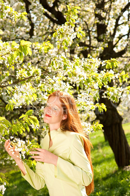 Young woman enjoying spring under blossom tree