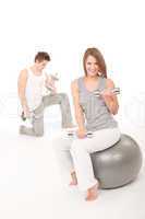 Fitness - Young couple training with weights and ball