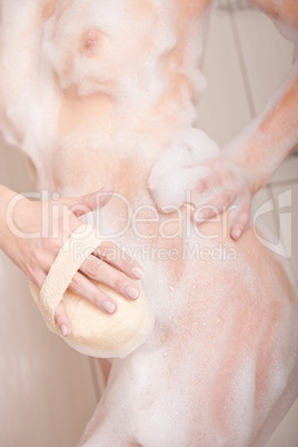 Body care: Woman in shower with washcloth and foam