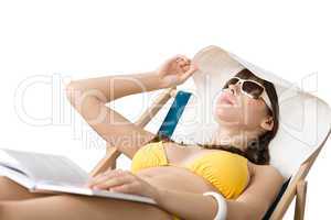 Beach - Woman in bikini lying sunbathing with book and hat
