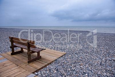 Wooden bench at a pebbles beach