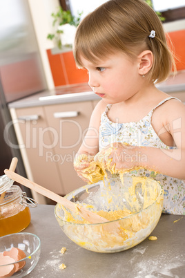 Child baking - little girl kneading dough